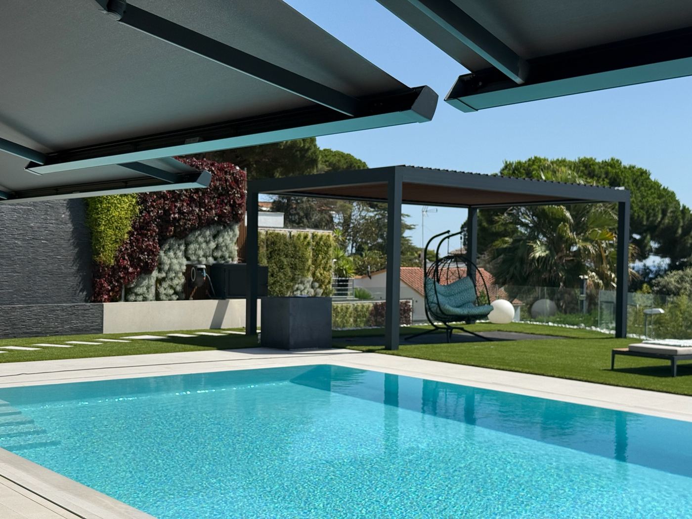 Pérgola bioclimática CERCA junto a la piscina de una vivienda en Sant Pol de Mar